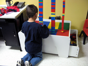 older boy building a Lego tower