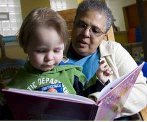 woman and young child share a book
